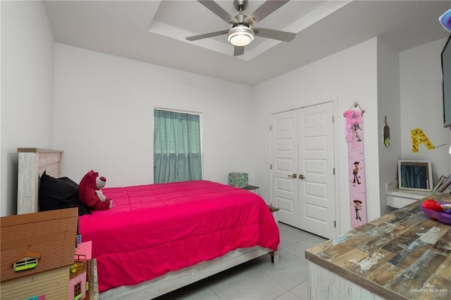 bedroom with light tile patterned floors, a closet, and a ceiling fan