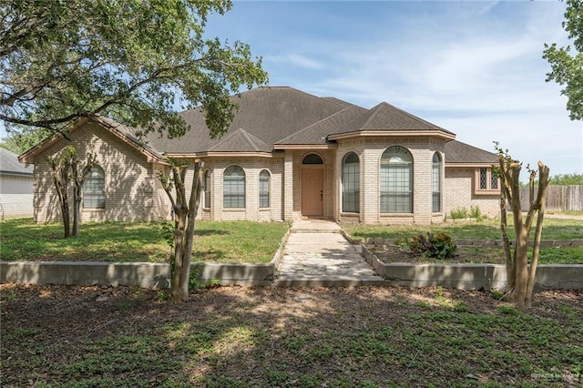 1302 N Glasscock Rd, Mission, TX 78572 - view of front of home with brick siding, fence, and a front yard