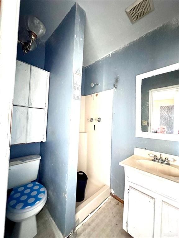 bathroom with vanity, toilet, and walk in shower