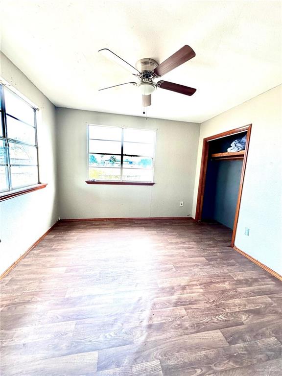 unfurnished bedroom with hardwood / wood-style floors, a closet, and ceiling fan