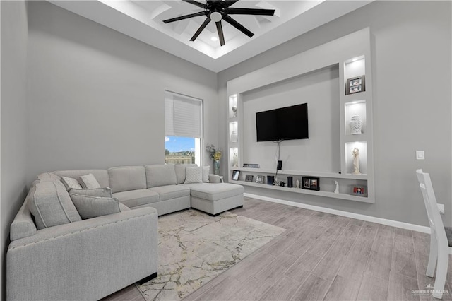 living room featuring ceiling fan, a high ceiling, and wood-type flooring