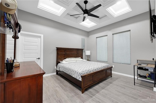 bedroom featuring ceiling fan, light wood-type flooring, and coffered ceiling