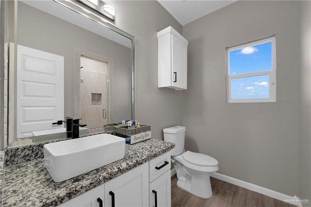 bathroom featuring an enclosed shower, vanity, wood-type flooring, and toilet