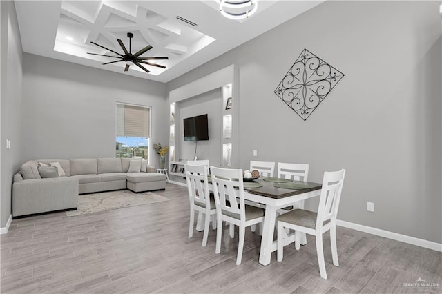 dining room with ceiling fan, beam ceiling, light hardwood / wood-style flooring, and coffered ceiling