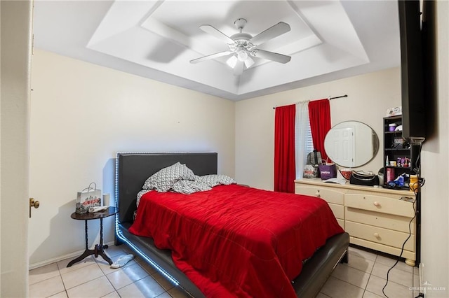 bedroom featuring ceiling fan, a raised ceiling, and light tile patterned floors