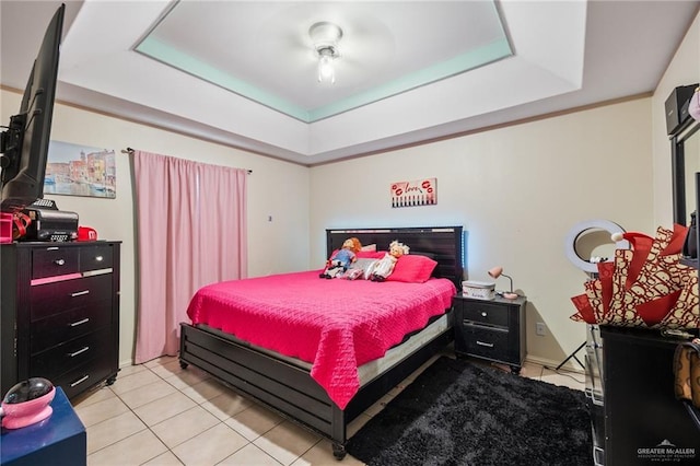 tiled bedroom featuring a raised ceiling