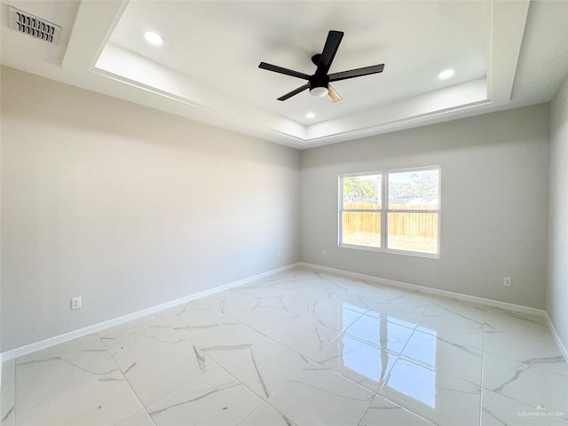 empty room with a tray ceiling and ceiling fan