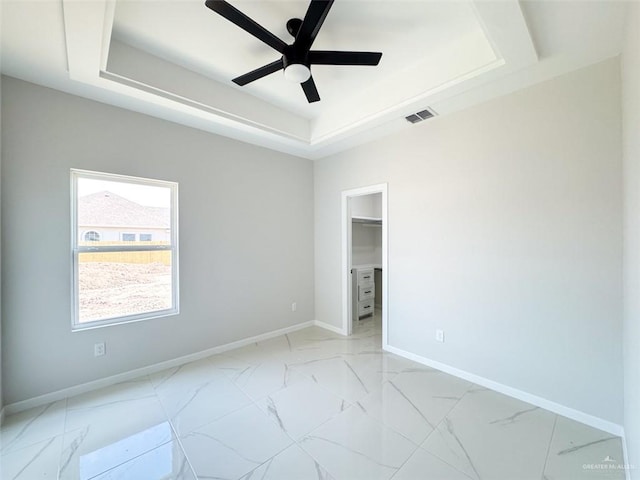 spare room with a raised ceiling and ceiling fan