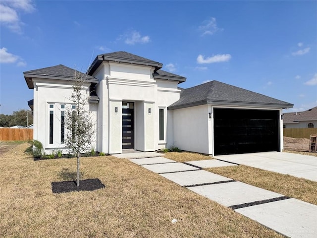 prairie-style home featuring a garage and a front lawn