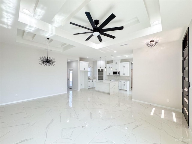 unfurnished living room featuring a raised ceiling and ceiling fan