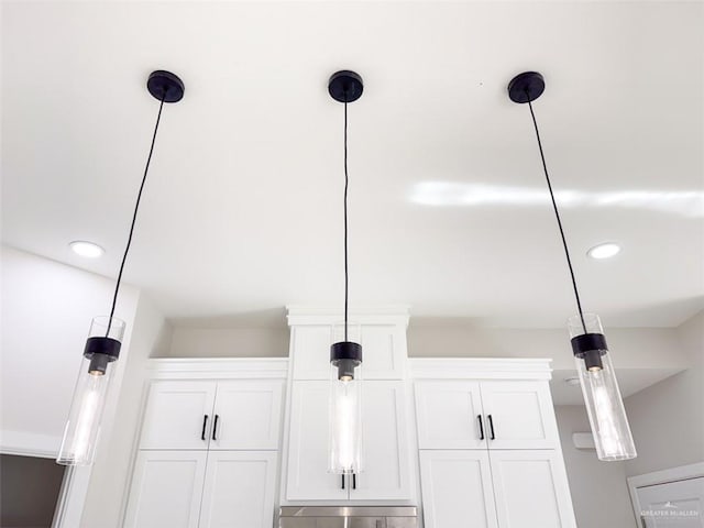 interior details featuring white cabinetry and hanging light fixtures