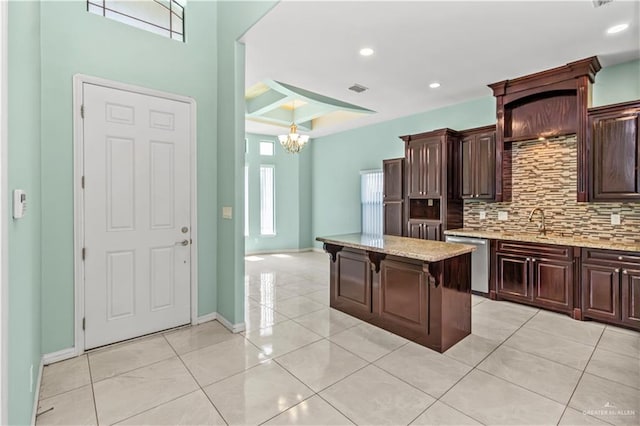 kitchen featuring stainless steel dishwasher, a center island, dark brown cabinetry, and a chandelier