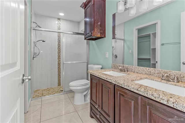 bathroom featuring tile patterned flooring, vanity, toilet, and walk in shower