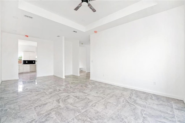 3609 E Santorini Dr, Edinburg, TX 78542 - spare room with marble finish floor, visible vents, a ceiling fan, a raised ceiling, and baseboards