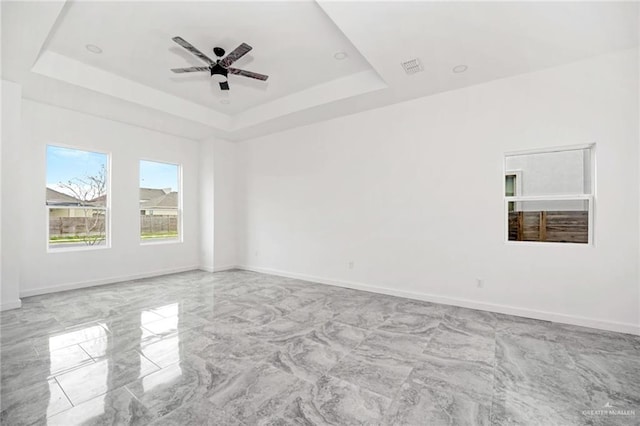 3609 E Santorini Dr, Edinburg, TX 78542 - spare room featuring marble finish floor, visible vents, a ceiling fan, a tray ceiling, and baseboards