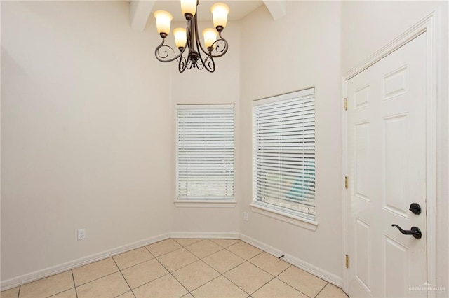 tiled empty room with a chandelier