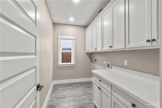 washroom with electric dryer hookup, cabinets, and washer hookup