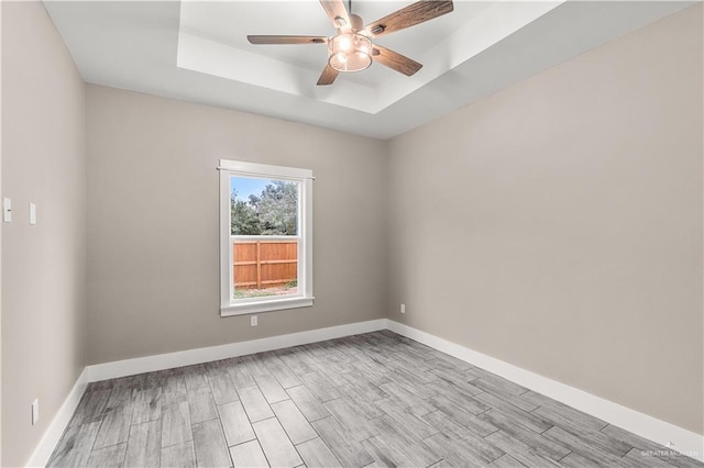 spare room featuring a tray ceiling and ceiling fan