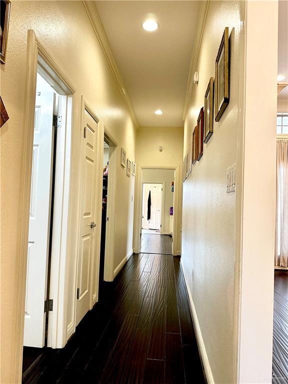 hallway with dark wood finished floors, baseboards, ornamental molding, and recessed lighting