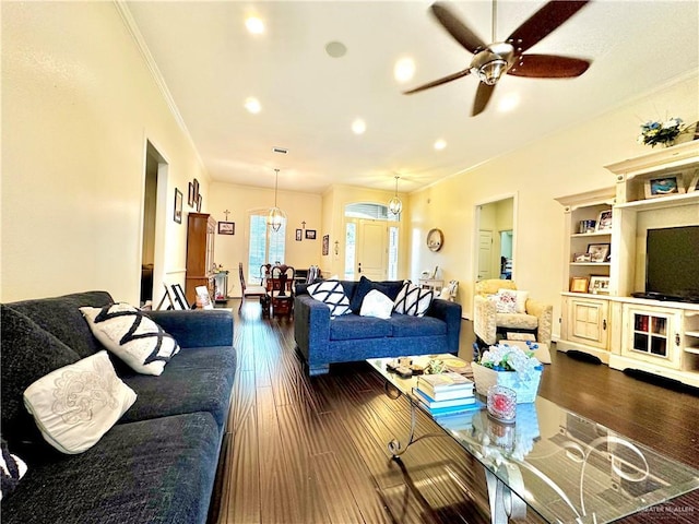 living room with ornamental molding, ceiling fan with notable chandelier, dark wood-type flooring, and recessed lighting