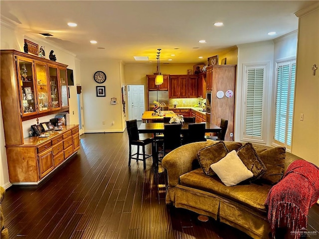 living area with baseboards, dark wood-style flooring, crown molding, and recessed lighting