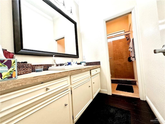 full bath with a shower stall, baseboards, wood finished floors, and vanity