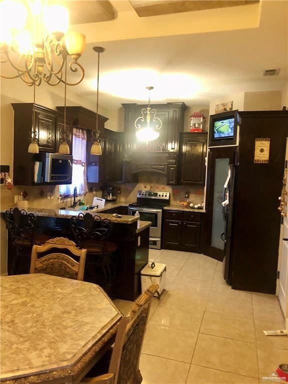 kitchen featuring stainless steel appliances, extractor fan, pendant lighting, light tile patterned floors, and a chandelier