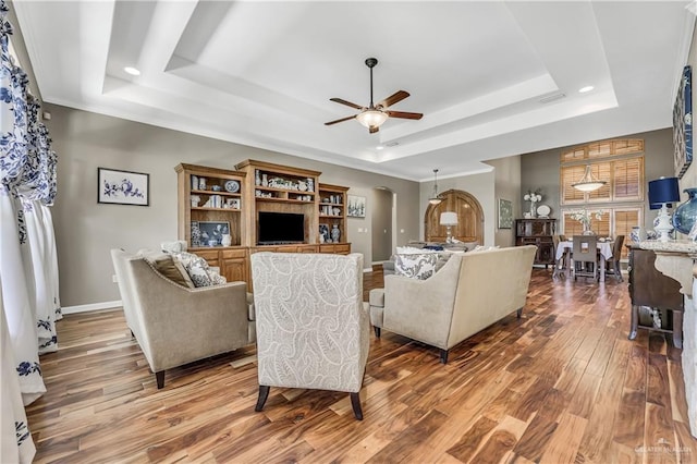 2504 Wernecke Ave, Mission, TX 78574 - living area with a raised ceiling, wood finished floors, a ceiling fan, arched walkways, and baseboards