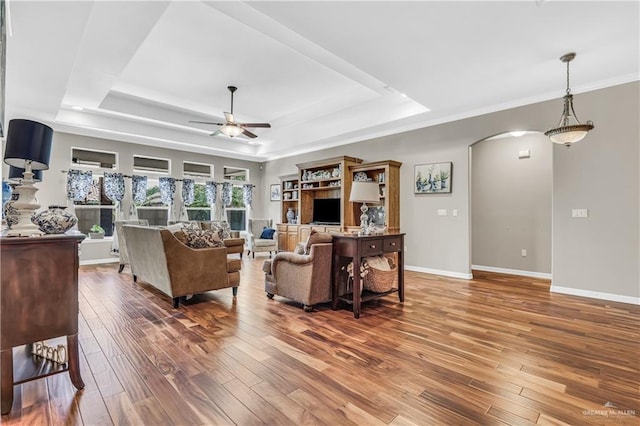 2504 Wernecke Ave, Mission, TX 78574 - living room featuring a tray ceiling, ceiling fan, arched walkways, wood finished floors, and baseboards