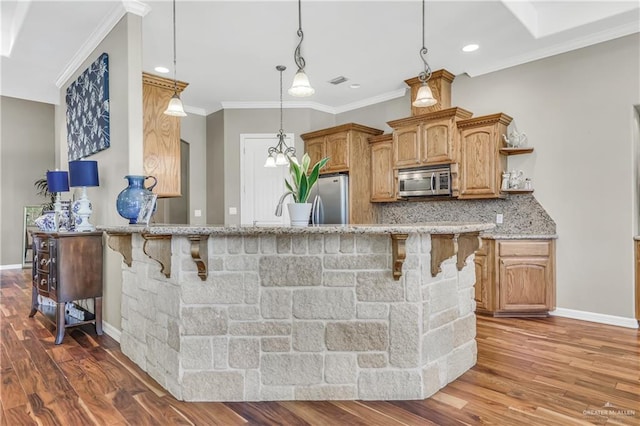 2504 Wernecke Ave, Mission, TX 78574 - kitchen with appliances with stainless steel finishes, a breakfast bar area, decorative backsplash, dark wood-style floors, and light stone countertops