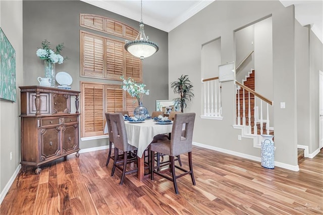 2504 Wernecke Ave, Mission, TX 78574 - dining room with wood finished floors, crown molding, baseboards, stairs, and a high ceiling