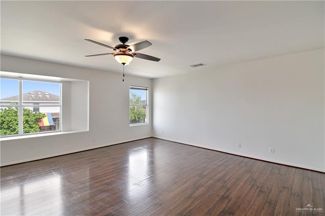 unfurnished room with dark hardwood / wood-style flooring and ceiling fan