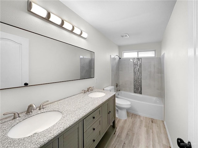 full bathroom with toilet, vanity, tiled shower / bath combo, and hardwood / wood-style flooring