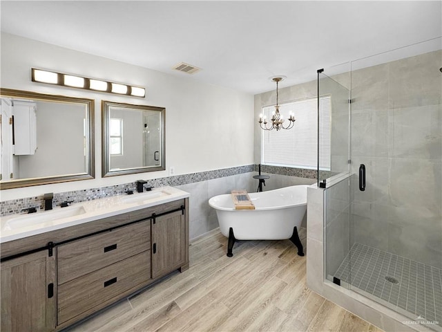 bathroom with hardwood / wood-style flooring, a notable chandelier, and a wealth of natural light