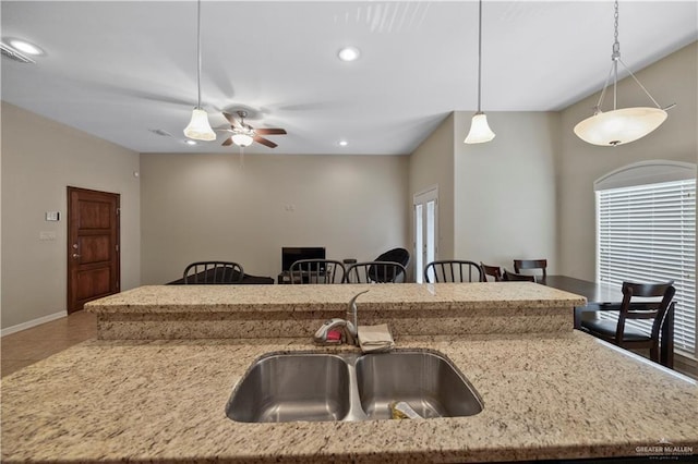 2715 Mimosa St Unit 9, Mission, TX 78572 - kitchen featuring a sink, decorative light fixtures, light stone countertops, a ceiling fan, and a kitchen island with sink