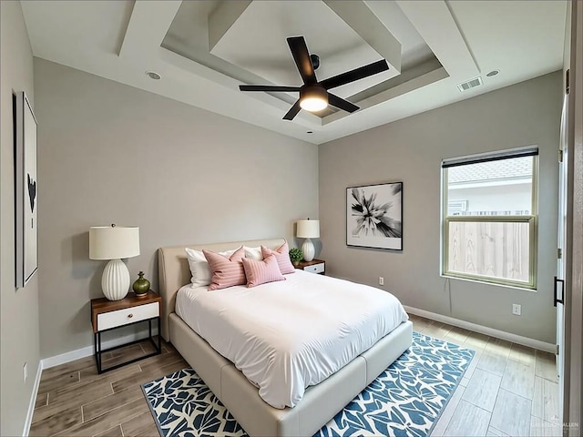 2411 Q St, Hidalgo, TX 78557 - bedroom with light wood-style floors, baseboards, a tray ceiling, and ceiling fan
