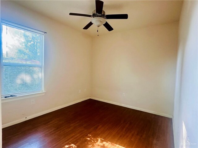 spare room with ceiling fan and dark wood-type flooring