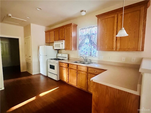 kitchen with white appliances, sink, hanging light fixtures, dark hardwood / wood-style flooring, and kitchen peninsula