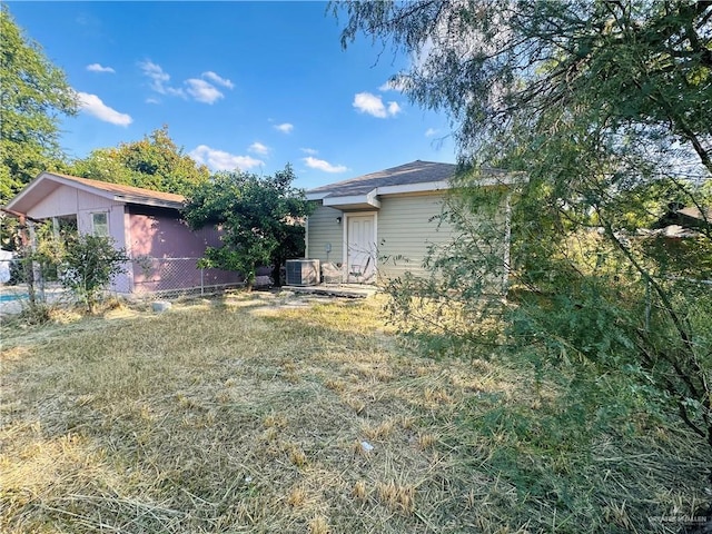 rear view of property with a lawn and central AC