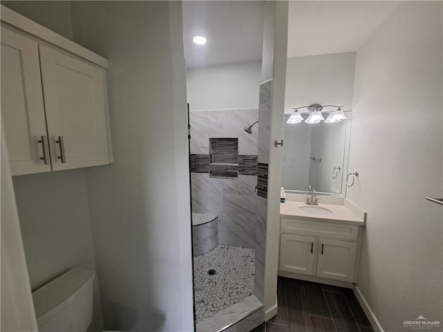 708 E 3rd Ave, Elsa, TX 78543 - bathroom featuring a tile shower, vanity, toilet, and baseboards
