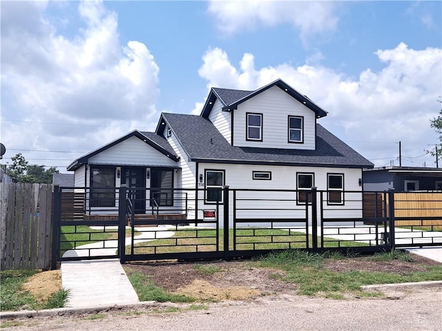 708 E 3rd Ave, Elsa, TX 78543 - view of front of home featuring a gate, a sunroom, roof with shingles, and a fenced front yard