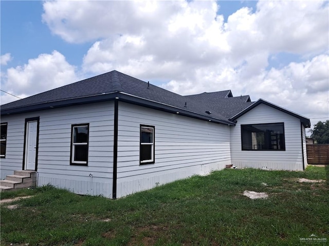 708 E 3rd Ave, Elsa, TX 78543 - view of home's exterior with entry steps, a lawn, and a shingled roof