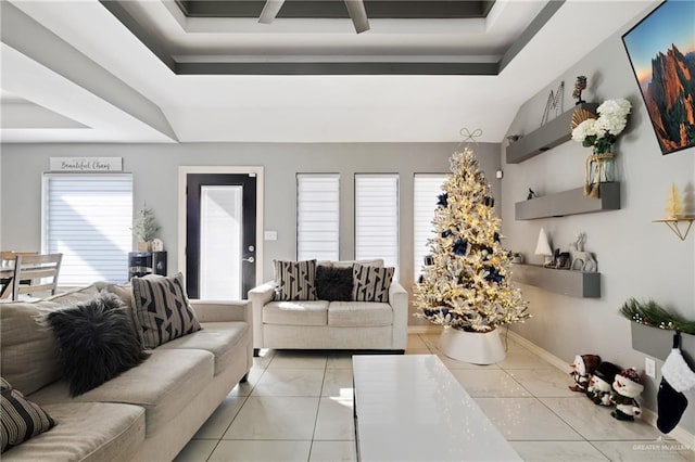 living room with light tile patterned floors and a tray ceiling