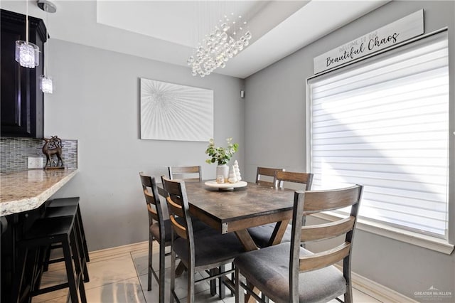 tiled dining space featuring an inviting chandelier