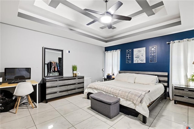 bedroom with ceiling fan and a tray ceiling