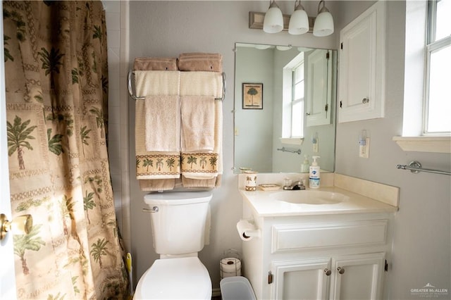 bathroom featuring vanity, curtained shower, and toilet