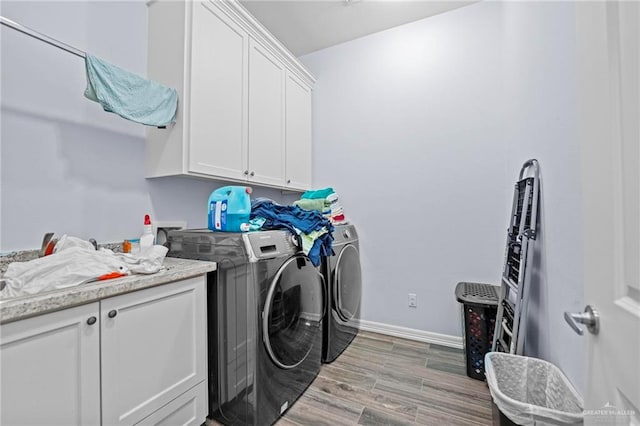 laundry room with cabinets, separate washer and dryer, and light hardwood / wood-style floors