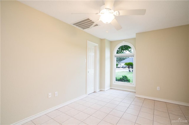 tiled spare room with ceiling fan