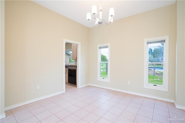 spare room featuring an inviting chandelier and light tile patterned floors