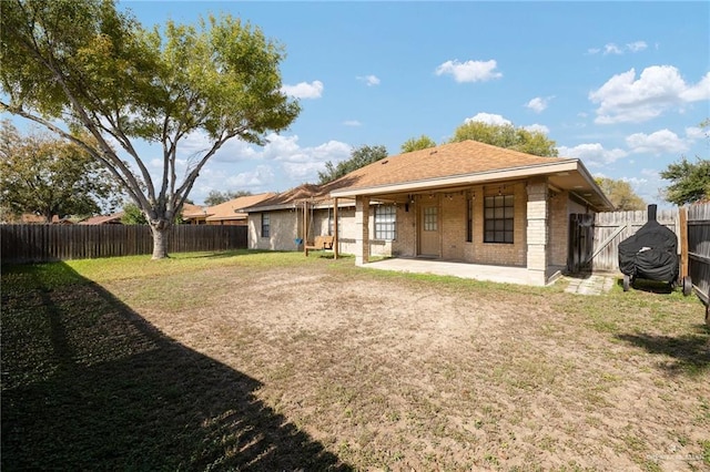 back of house with a yard and a patio